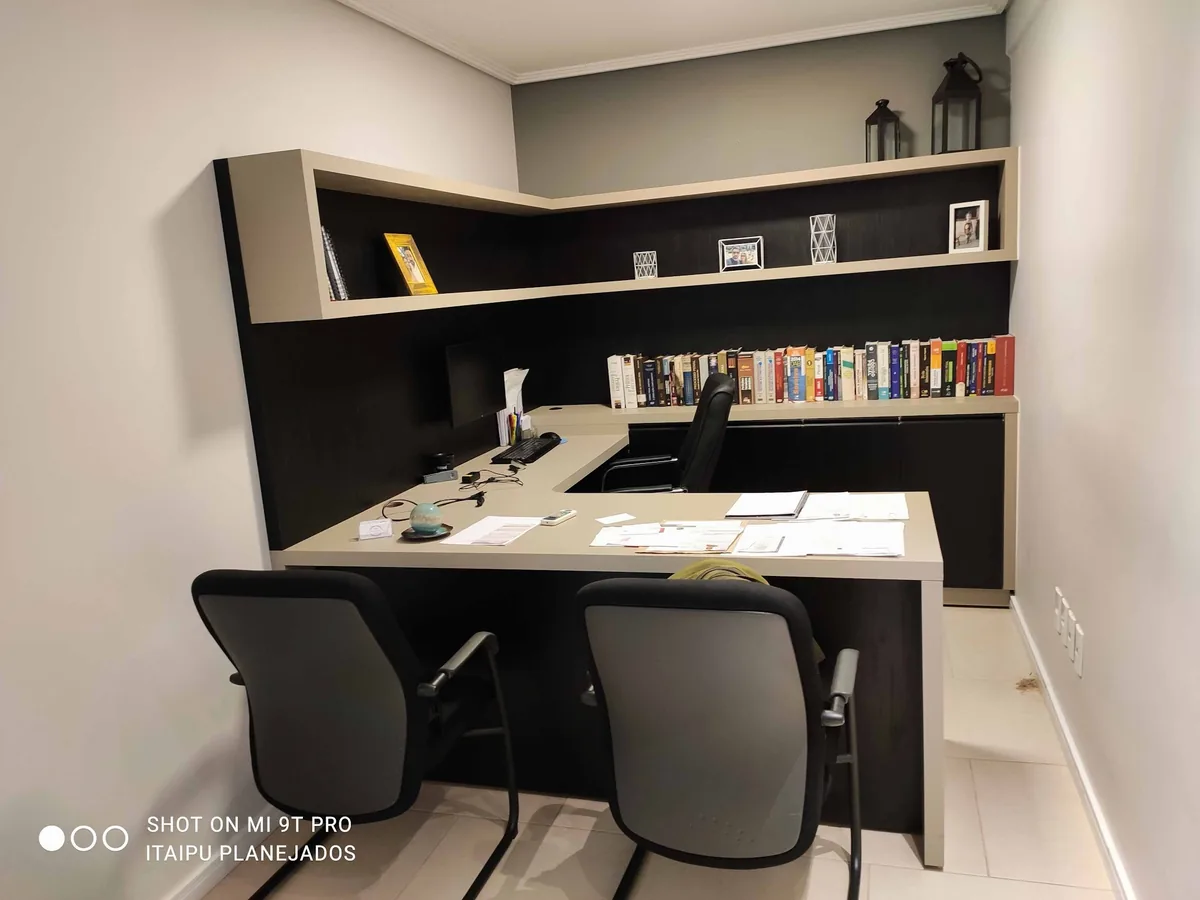 Escritório planejado com bancada, gavetas e estante em tons escuros